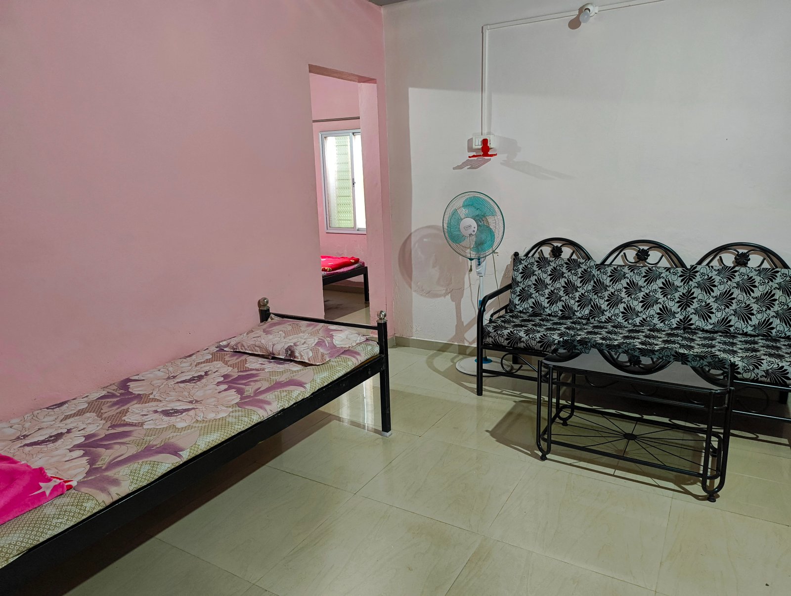 A living area with a single bed and sofa