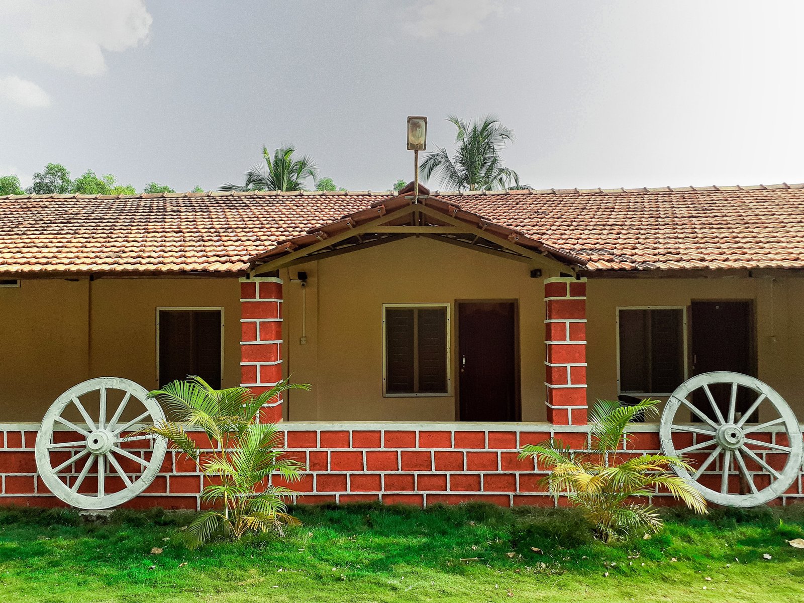 The front view of Atithi Homestay with its traditional tiled roof and brick pillars